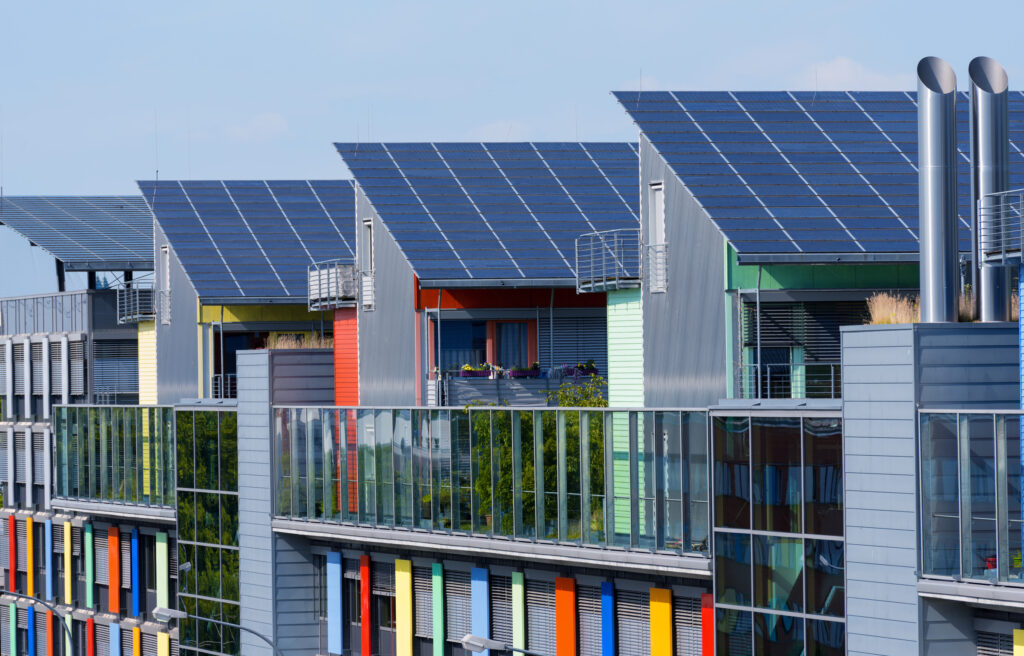 Auf einer Häuserreihe sind PV-Anlagen auf dem Dach zu erkennen. Diese sind mit den EE-Anlagen gemeint.