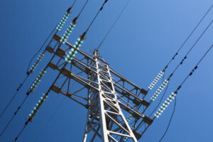 Ein Strommast in Nahaufnahme vor blauem Himmel