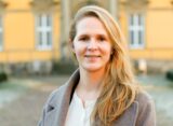 Johanna Wolff steht vor dem Gebäude der Universität Osnabrück.